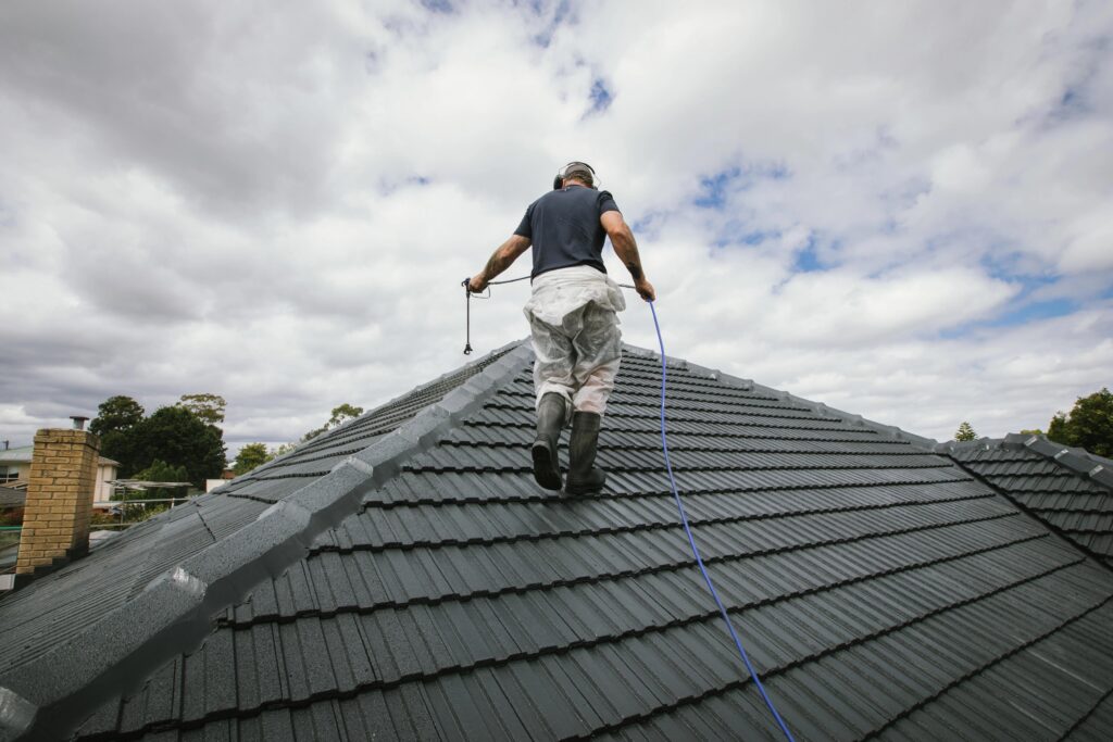 Roof painting contractor inspecting a Colorbond roof before painting