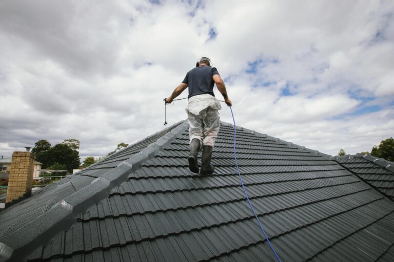 Roof painting contractor inspecting a Colorbond roof before painting