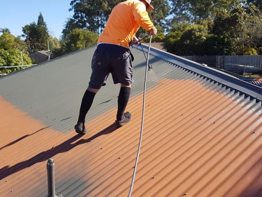 Roof painter applying coating to a metal roof in Perth