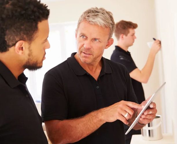 Commercial painter discussing painting project requirements with a client