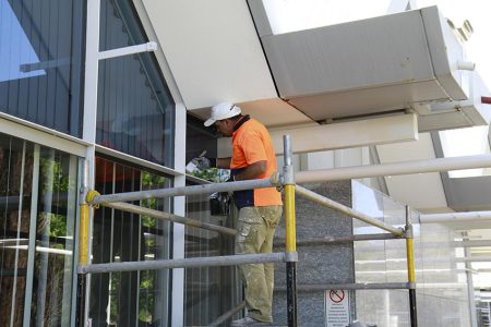 Commercial painter working on a building exterior in Perth WA
