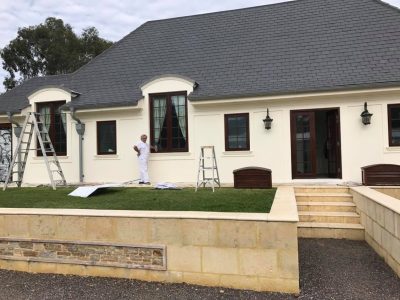 Painter completing exterior residential painting on a Perth home
