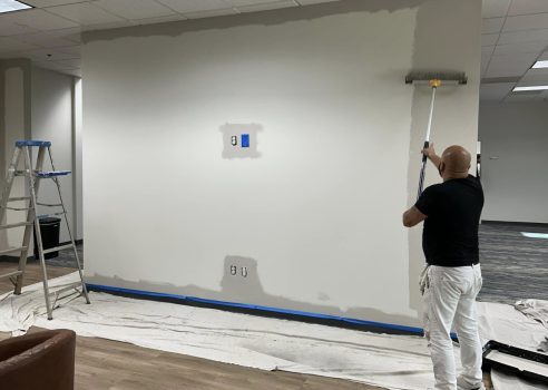Painter applying a suitable paint finish inside a Perth office